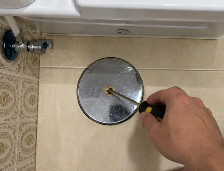 Tapa de bote sifónico nueva en el suelo del baño